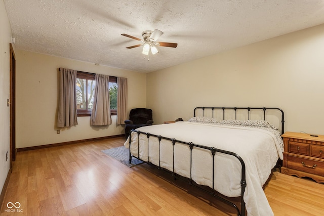 bedroom featuring a textured ceiling, light wood-type flooring, and ceiling fan