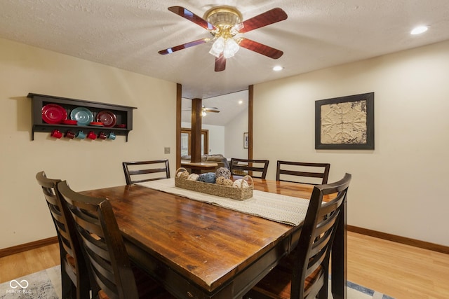 dining area with ceiling fan, light wood-type flooring, and a textured ceiling