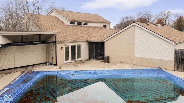 rear view of house featuring a patio area and a covered pool