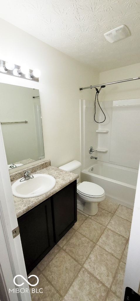 full bathroom featuring tile patterned flooring, shower / bath combination, a textured ceiling, toilet, and vanity