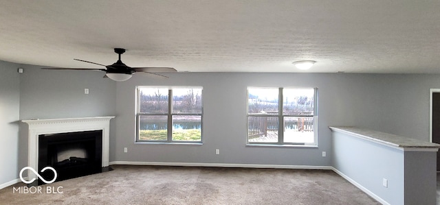 unfurnished living room featuring light colored carpet, plenty of natural light, and ceiling fan