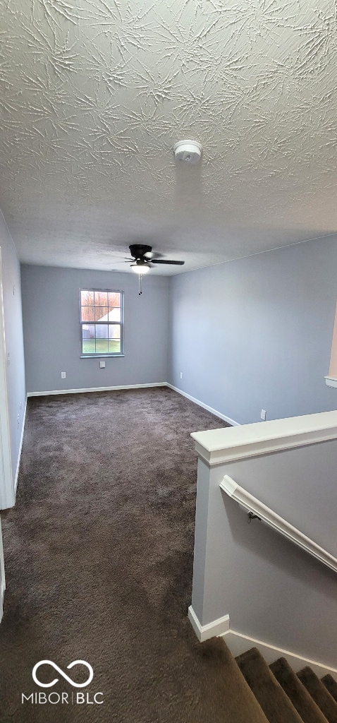 carpeted empty room with a textured ceiling