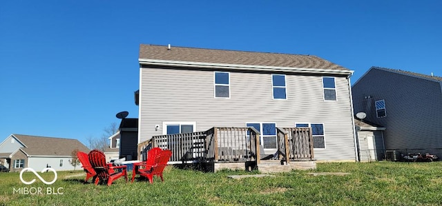 rear view of house with a lawn and a wooden deck