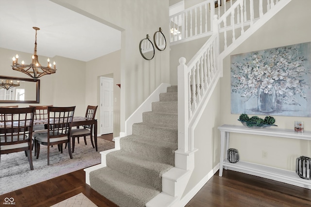 stairway with a chandelier and wood-type flooring