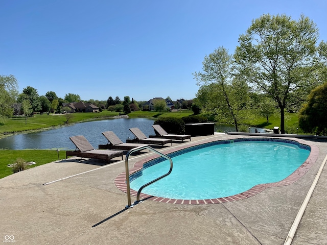 view of swimming pool with a lawn, a water view, and a patio