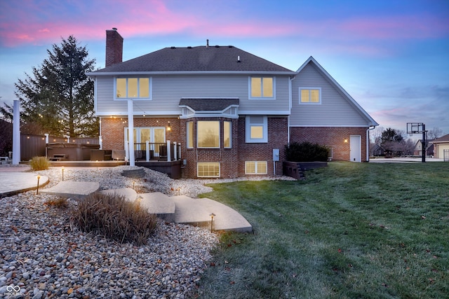 back house at dusk with a lawn