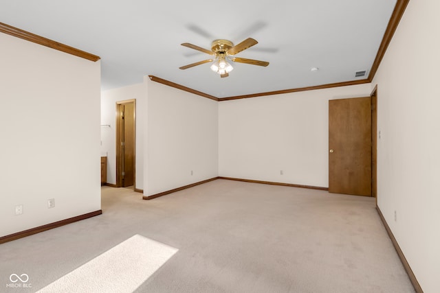 spare room featuring light colored carpet, ceiling fan, and ornamental molding