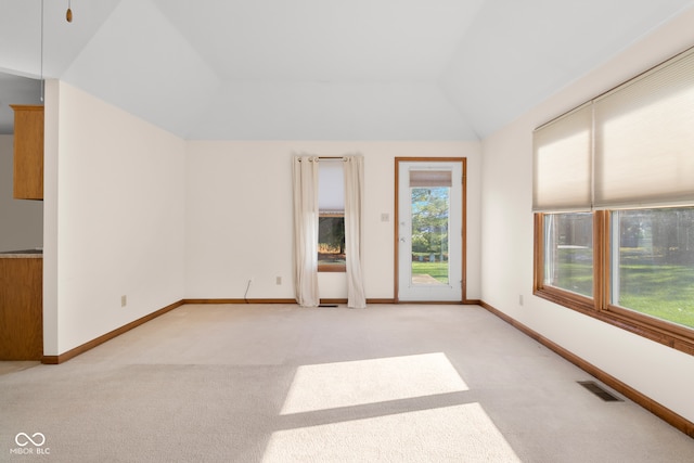 carpeted spare room featuring lofted ceiling