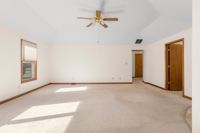 carpeted spare room featuring vaulted ceiling and ceiling fan