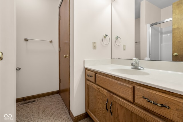 bathroom with a shower, tile patterned flooring, and vanity