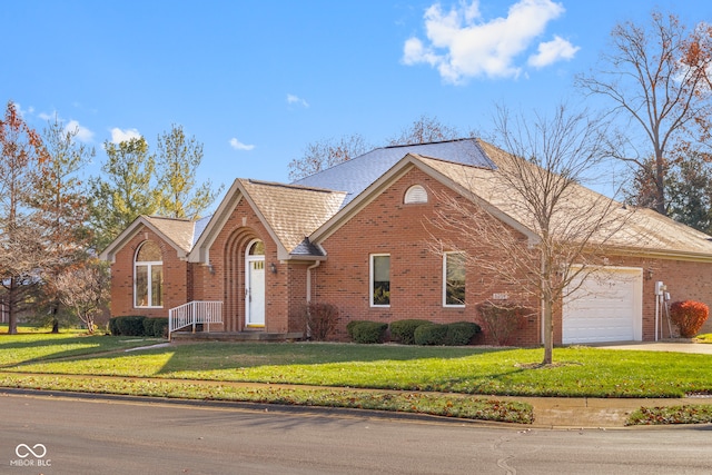 view of front of property with a front yard and a garage