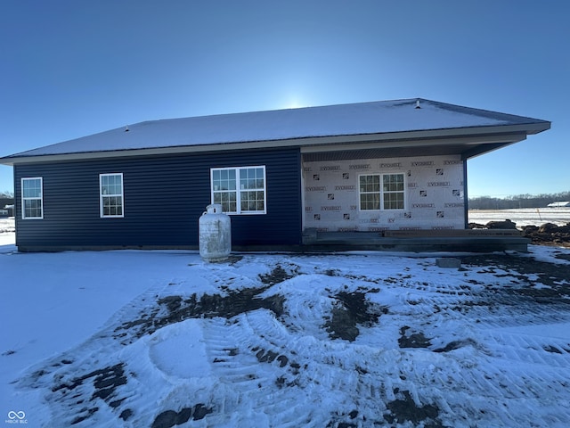 view of snow covered back of property