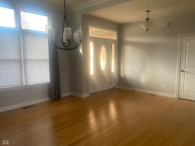 interior space featuring a chandelier, hardwood / wood-style floors, and ornamental molding