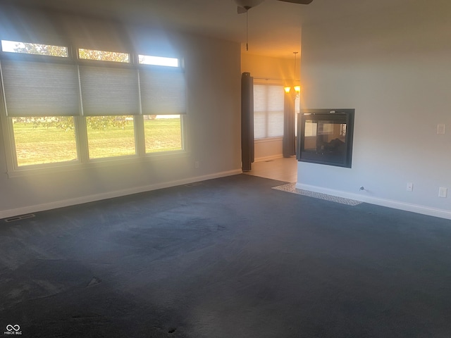 unfurnished room featuring dark colored carpet and ceiling fan