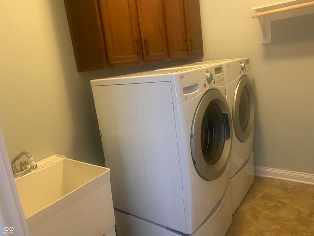 laundry room featuring separate washer and dryer, sink, and cabinets