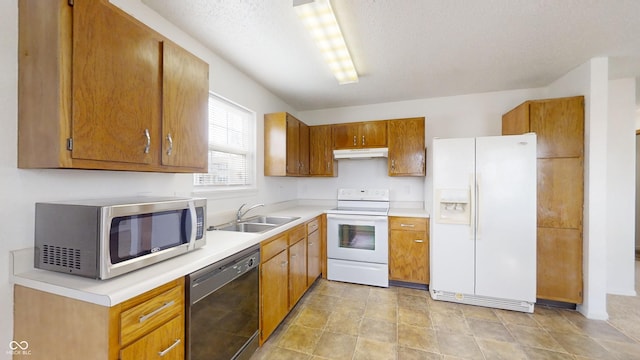 kitchen with a textured ceiling, sink, and white appliances