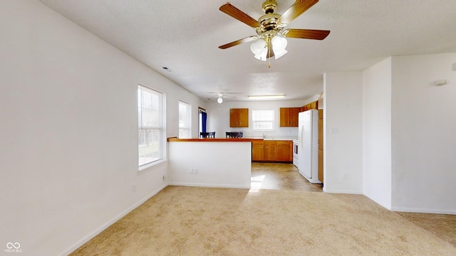 kitchen featuring light carpet, kitchen peninsula, a textured ceiling, ceiling fan, and white fridge