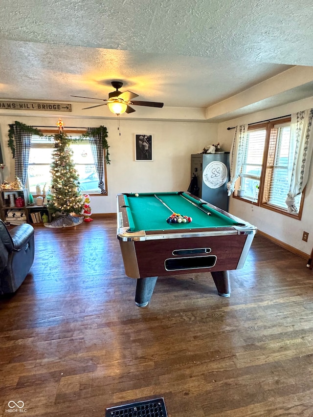 game room featuring ceiling fan, dark hardwood / wood-style floors, a textured ceiling, and pool table