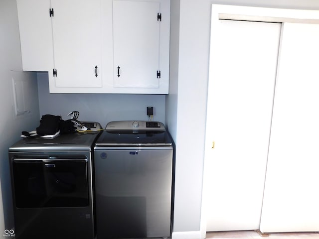 washroom featuring cabinets and separate washer and dryer