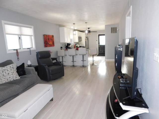 living room featuring light wood-type flooring and ceiling fan