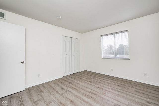 unfurnished bedroom featuring a closet and light hardwood / wood-style flooring