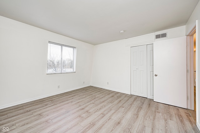 unfurnished bedroom featuring a closet and light hardwood / wood-style flooring