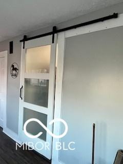 interior details featuring a barn door and hardwood / wood-style flooring