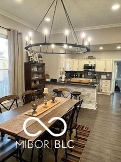 dining space with ornamental molding and dark wood-type flooring