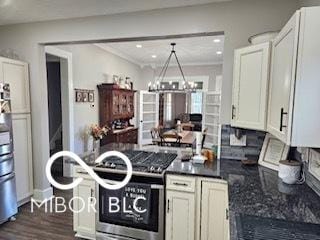 kitchen featuring white cabinets, dark hardwood / wood-style floors, stainless steel stove, and a chandelier