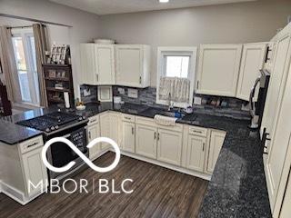 kitchen featuring backsplash, sink, electric range, dark stone countertops, and dark hardwood / wood-style floors