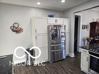 kitchen with dark stone countertops, dark wood-type flooring, white cabinets, and stainless steel appliances