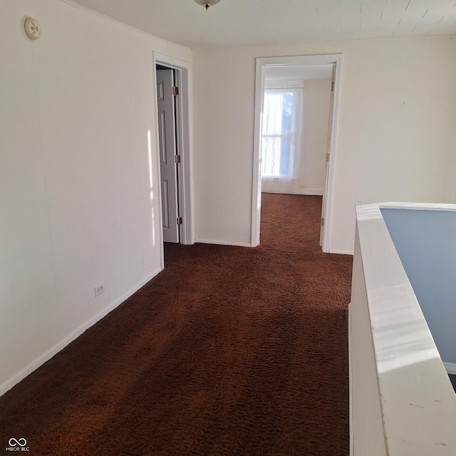 hall featuring dark colored carpet