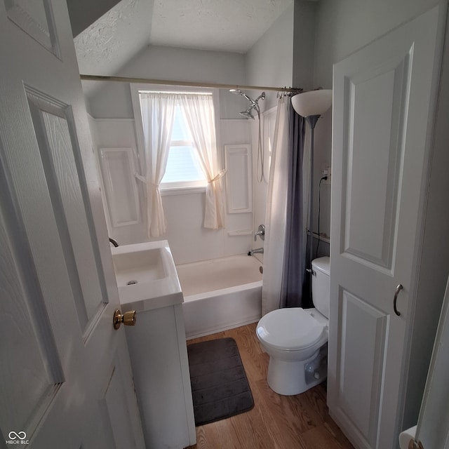 full bathroom with shower / bath combo, vanity, hardwood / wood-style flooring, toilet, and a textured ceiling