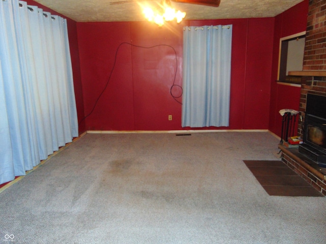 living room featuring ceiling fan, carpet, and a textured ceiling