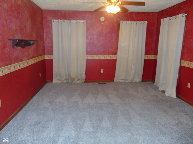 carpeted bedroom featuring ceiling fan and a textured ceiling