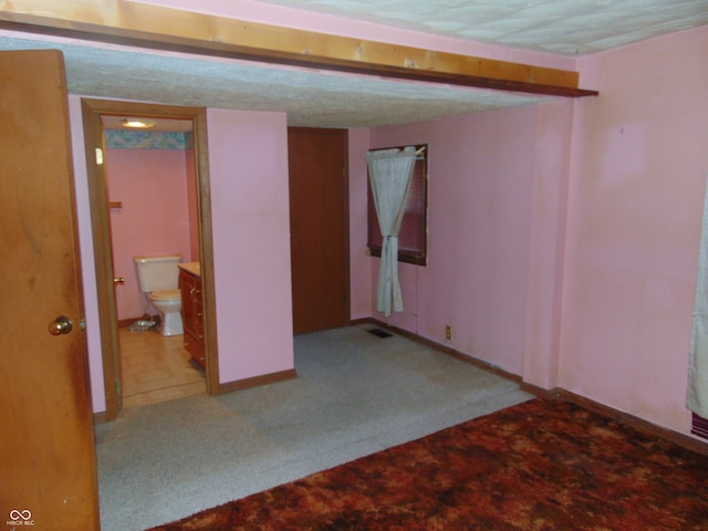 basement featuring carpet flooring and a textured ceiling