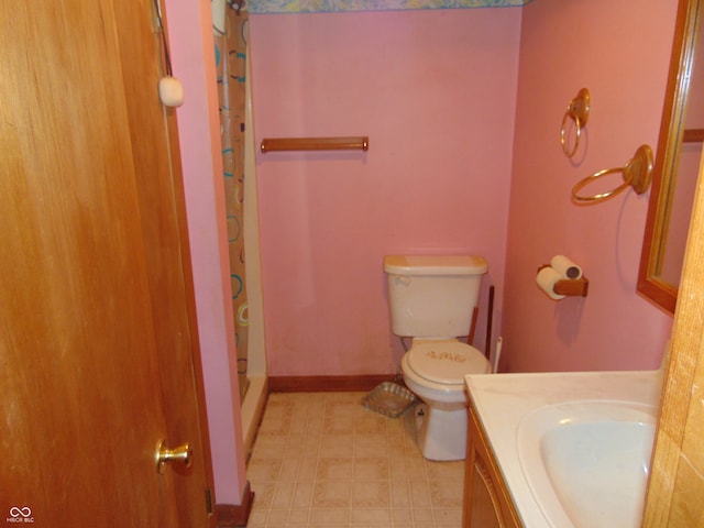 bathroom with toilet, vanity, and walk in shower