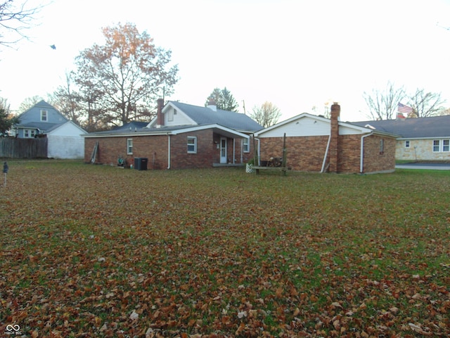 rear view of house with a lawn and central AC unit