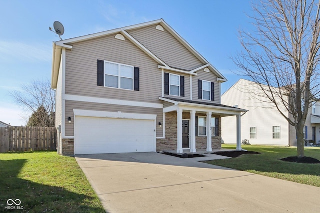 view of front of house with a front yard, a garage, and covered porch