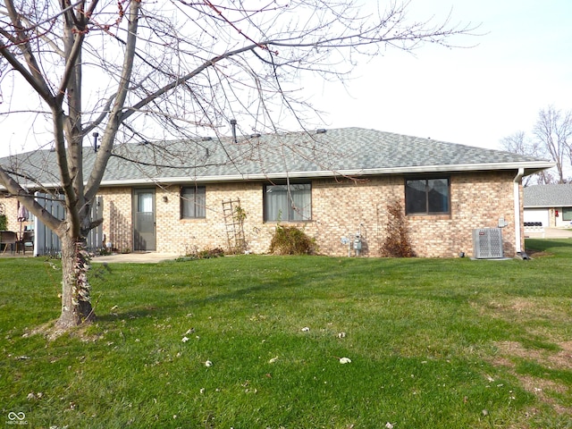 back of house with a yard and central AC