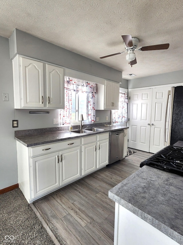 kitchen with appliances with stainless steel finishes, sink, white cabinets, and ceiling fan