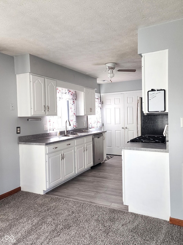 kitchen featuring dishwasher, sink, white cabinets, stove, and ceiling fan