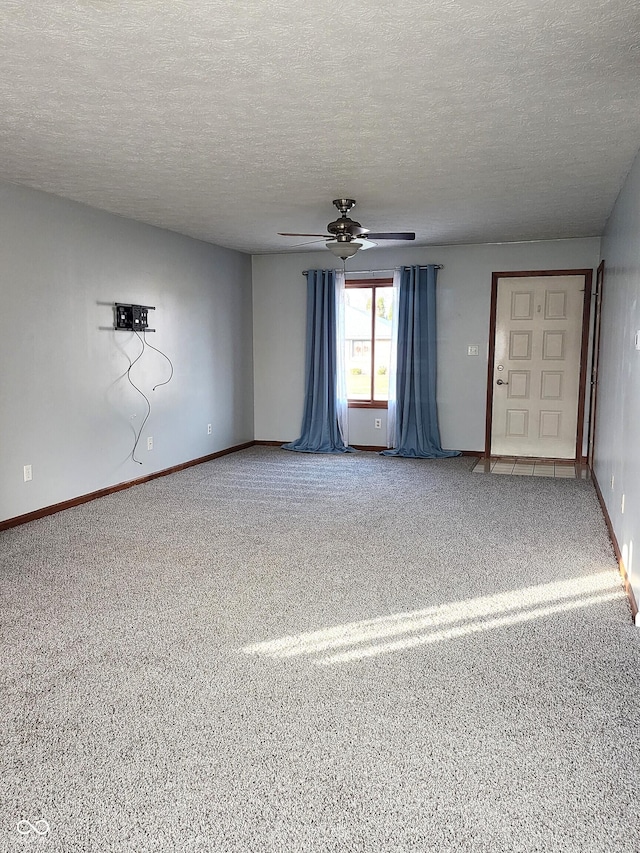 unfurnished room with ceiling fan, carpet flooring, and a textured ceiling