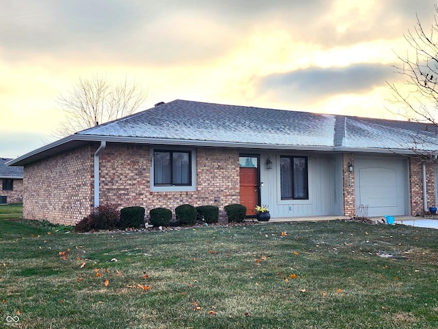 single story home with a garage and a lawn