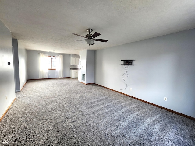 unfurnished living room with a textured ceiling, carpet floors, and ceiling fan