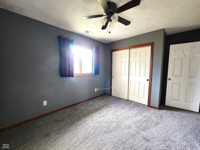 unfurnished bedroom featuring a textured ceiling, a closet, ceiling fan, and carpet flooring