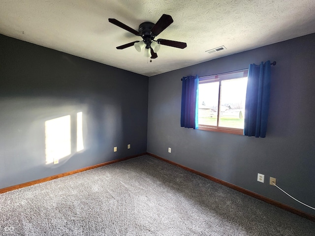 carpeted empty room with ceiling fan and a textured ceiling