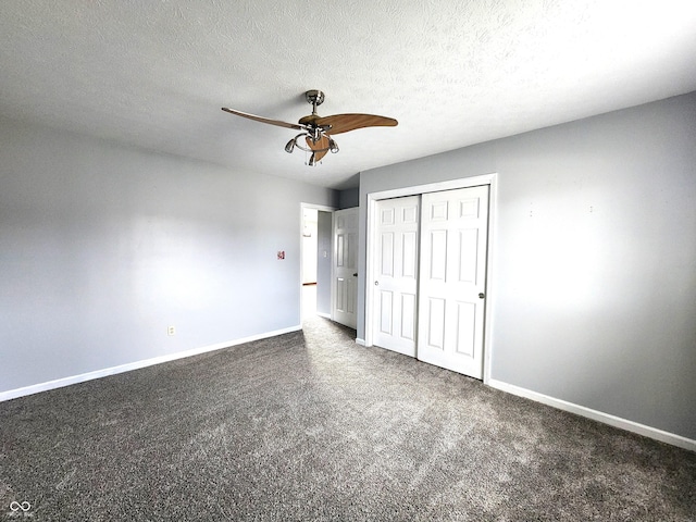 unfurnished bedroom featuring ceiling fan, dark carpet, a closet, and a textured ceiling