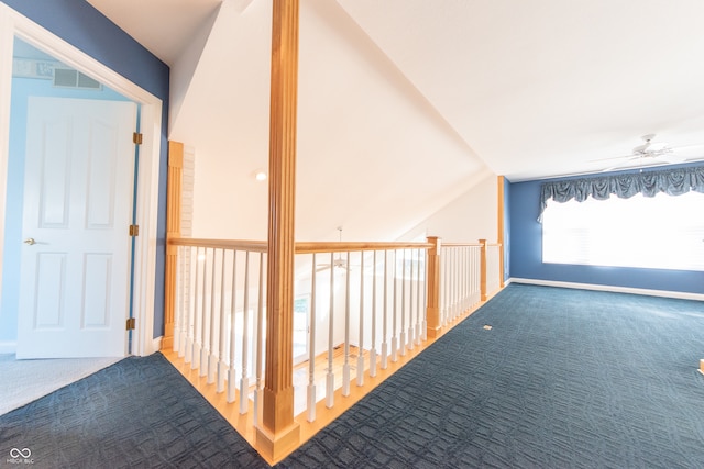 hallway featuring carpet floors and vaulted ceiling