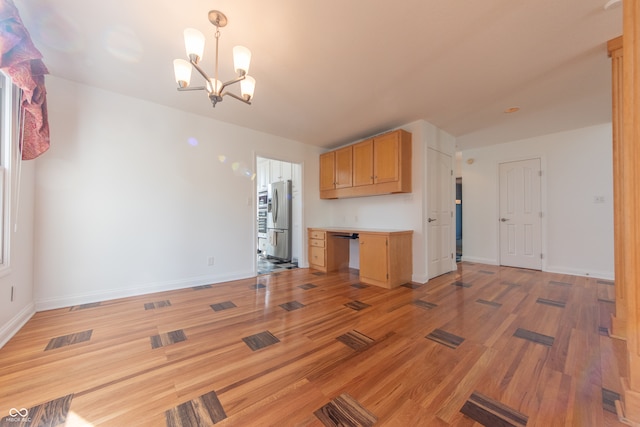 kitchen featuring stainless steel fridge, hardwood / wood-style flooring, and an inviting chandelier